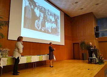 Karin Zettler bittet die AbsolventInnen des ersten BIS Diplomstudiengangs auf die Bühne (im Hintergrund: Bild bei der Studienaufnahme 1988); Foto: BIS LU